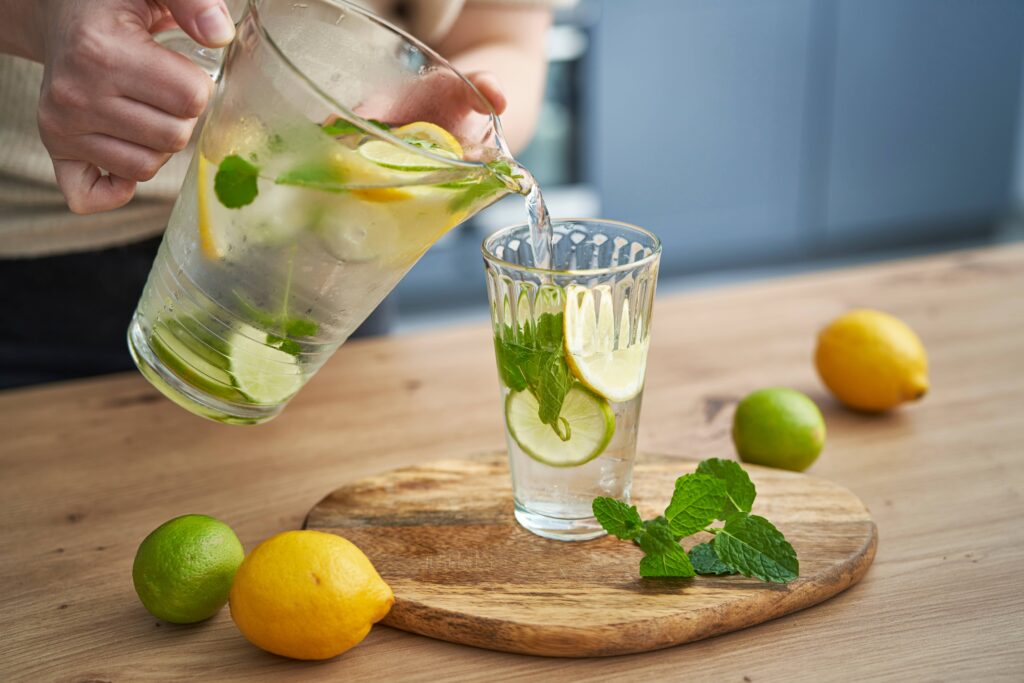 Femme servant une limonade d'un pichet dans un verre d'eau